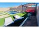 A backyard pool featuring a pergola, comfortable seating, and a pristine artificial grass surround at 21255 W Ashland Ave, Buckeye, AZ 85396