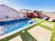 Stunning backyard pool featuring lush turf, comfortable lounge chairs, and a tranquil water feature, creating a private retreat at 21255 W Ashland Ave, Buckeye, AZ 85396
