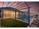 Backyard pool with pergola, artificial grass, and view of the home's exterior at 21255 W Ashland Ave, Buckeye, AZ 85396
