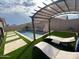 Inviting backyard pool featuring a shaded pergola, comfortable lounge chairs, and lush turf, creating an ideal outdoor retreat at 21255 W Ashland Ave, Buckeye, AZ 85396
