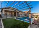 Backyard pool with pergola, artificial grass, and view of the home's exterior at 21255 W Ashland Ave, Buckeye, AZ 85396