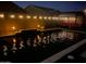 A stunning backyard pool featuring ambient lighting and a cozy seating area with a red sofa at 21255 W Ashland Ave, Buckeye, AZ 85396