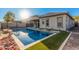 Backyard pool with grey home exterior, artificial grass, and rock landscaping at 21255 W Ashland Ave, Buckeye, AZ 85396