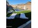 Backyard pool and deck featuring modern chaise lounges, lush turf, and decorative pavers for outdoor entertainment at 21255 W Ashland Ave, Buckeye, AZ 85396