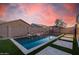 Inviting backyard pool with water feature, travertine deck, and lush artificial turf at 21255 W Ashland Ave, Buckeye, AZ 85396