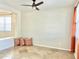 Bright living room with tan tile flooring, accent pillows, and a ceiling fan at 2315 E Pecan Rd, Phoenix, AZ 85040
