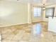 Open-concept living room featuring tan tile flooring, a window with blinds, and neutral paint at 2315 E Pecan Rd, Phoenix, AZ 85040