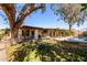 Expansive backyard featuring grass, a covered patio, mature trees and a refreshing pool at 2407 W Paradise Ln, Phoenix, AZ 85023