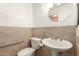 Comfortable half-bathroom features neutral tile, pedestal sink and accessibility handrail at 2407 W Paradise Ln, Phoenix, AZ 85023