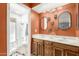 A bathroom features dual sinks, wooden cabinets, and a walk-in shower with glass doors at 2407 W Paradise Ln, Phoenix, AZ 85023