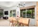 A dining room features a light wood table, seating for six, and large windows providing ample natural light at 2407 W Paradise Ln, Phoenix, AZ 85023