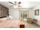 A main bedroom offers a unique accent wall, a ceiling fan, and a sliding glass door to the backyard pool at 2407 W Paradise Ln, Phoenix, AZ 85023