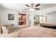 A main bedroom offers a tranquil space with neutral tones, a ceiling fan, and views of an ensuite bathroom at 2407 W Paradise Ln, Phoenix, AZ 85023