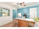 An office features a white and brown desk, light wood flooring, and a window overlooking the yard at 2407 W Paradise Ln, Phoenix, AZ 85023