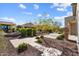 Beautifully landscaped backyard featuring lush greenery, manicured bushes, and decorative rock at 26635 W Covey Ln, Buckeye, AZ 85396