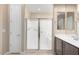 Bright bathroom showcasing tiled shower with glass doors, neutral tones, and double sinks at 26635 W Covey Ln, Buckeye, AZ 85396