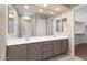 Neutral toned bathroom featuring double sinks, large mirror, and walk-in closet at 26635 W Covey Ln, Buckeye, AZ 85396