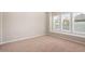 This empty bedroom has a large window, neutral walls, and carpeted floor at 26635 W Covey Ln, Buckeye, AZ 85396