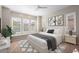 This bedroom features a ceiling fan, a large bed, and large shuttered windows at 26635 W Covey Ln, Buckeye, AZ 85396