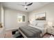 Staged bedroom featuring a queen sized bed, window with shutters, and modern ceiling fan at 26635 W Covey Ln, Buckeye, AZ 85396
