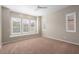 The unfurnished bedroom features shuttered windows, a ceiling fan, and neutral walls at 26635 W Covey Ln, Buckeye, AZ 85396