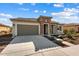 Beautifully landscaped front yard with a stone accent facade and a spacious driveway leading to a two-car garage at 26635 W Covey Ln, Buckeye, AZ 85396