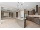 Open kitchen with a large granite island, stainless appliances and views to the living area at 26635 W Covey Ln, Buckeye, AZ 85396