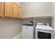 Laundry room with washer, dryer, upper cabinets, and shelving at 26635 W Covey Ln, Buckeye, AZ 85396