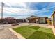 Charming backyard featuring artificial grass, a fire pit, and a cozy outdoor dining area at 2925 W Highland Ave, Phoenix, AZ 85017