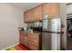 A kitchen area featuring wooden cabinets, a stainless steel fridge, and granite countertops at 2925 W Highland Ave, Phoenix, AZ 85017