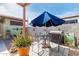 Outdoor patio with a table, chairs, a large umbrella, and decorative potted plants at 2925 W Highland Ave, Phoenix, AZ 85017