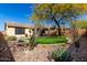 Expansive backyard with a lush putting green surrounded by desert landscaping and mature trees at 2951 W Plum Hollow Dr, Anthem, AZ 85086
