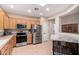Well-lit kitchen featuring stainless steel appliances, light wood cabinetry, and tile flooring at 2951 W Plum Hollow Dr, Anthem, AZ 85086