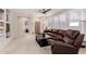 Comfortable living room with a plush leather sofa, a ceiling fan, and plantation shutters at 2951 W Plum Hollow Dr, Anthem, AZ 85086