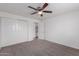 Bright bedroom features a ceiling fan, closet, and neutral carpet at 3217 E Friess Dr, Phoenix, AZ 85032