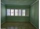 Vacant bedroom with light green walls and hardwood floors, featuring natural light from the window at 349 E Thomas Rd # E402, Phoenix, AZ 85012
