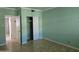 Vacant bedroom with light green walls and hardwood floors, featuring a closet and door to bathroom at 349 E Thomas Rd # E402, Phoenix, AZ 85012