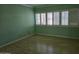 Vacant bedroom with light green walls and hardwood floors, featuring natural light from the window at 349 E Thomas Rd # E402, Phoenix, AZ 85012