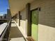 Hallway view featuring a light green door with the unit number E-402 on the door with a neutral colored rug in front of the door at 349 E Thomas Rd # E402, Phoenix, AZ 85012