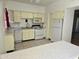 Bright kitchen featuring white appliances, light yellow cabinets and a window with a red curtain at 349 E Thomas Rd # E402, Phoenix, AZ 85012