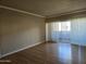 Large, empty living room with hardwood floors and a sliding glass door to the balcony at 349 E Thomas Rd # E402, Phoenix, AZ 85012