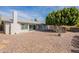 A view of the backyard with a gravel ground cover, patio, and partial block wall at 4325 E Sacaton St, Phoenix, AZ 85044