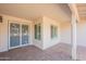 Charming covered front porch with brick flooring, security gate, and dual windows at 4325 E Sacaton St, Phoenix, AZ 85044