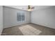 Bedroom with neutral carpet, ceiling fan, and a large window at 43646 W Elizabeth Ave, Maricopa, AZ 85138