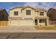 Inviting two-story home featuring a three-car garage and neutral stucco exterior at 43646 W Elizabeth Ave, Maricopa, AZ 85138