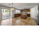 Bright kitchen with island, stainless appliances, wood cabinetry, and access to outdoor patio at 43646 W Elizabeth Ave, Maricopa, AZ 85138