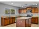 Well-lit kitchen with a practical island, stainless steel appliances, and wood cabinets at 43646 W Elizabeth Ave, Maricopa, AZ 85138