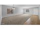 Bright, spacious living room with neutral carpet and tile, complemented by natural light from large windows at 43646 W Elizabeth Ave, Maricopa, AZ 85138