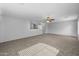 Large, open living room with a ceiling fan and neutral paint and carpet at 43646 W Elizabeth Ave, Maricopa, AZ 85138