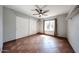 Empty bedroom showcasing tile flooring, a ceiling fan, window with security bars, and a large sliding-door closet at 4916 E Hopi St, Phoenix, AZ 85044